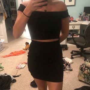 Black off the shoulder mini dress with a slit.